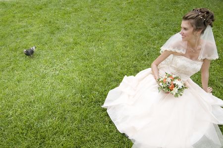 Young bride in a green park looking at the pigeon.
の写真素材