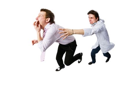 Patient running away from a doctor  isolated on whiteの写真素材