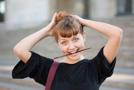 Red-haired girl fixes her hair with a hair-pinの写真素材