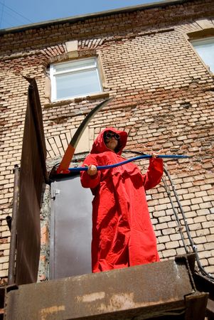 Girl in red hood with a scythe making a threatning swing from aboveの写真素材