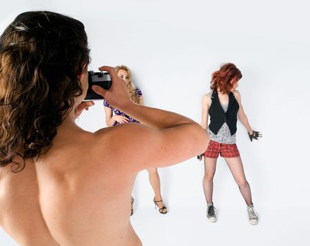 Young man photographing beautiful girls at the studioの写真素材