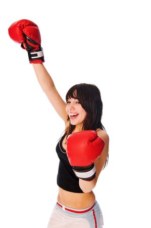 Girl wearing boxing gloves with a rised hand on whiteの写真素材