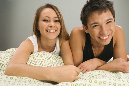 Happy young couple in bed togetherの写真素材