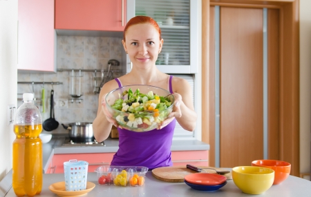 Beautiful red woman with fresh saladの写真素材