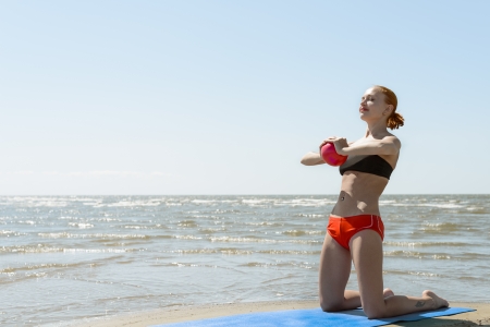 Beautiful woman practicing fitness by the seaの写真素材
