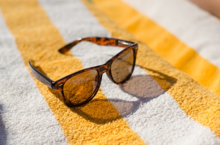 Sunglasses on yellow beach towelの写真素材