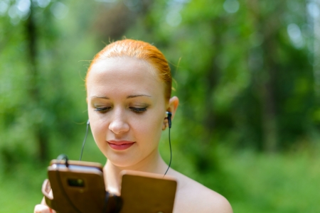 Attractive young woman listening to music with mp3 player and earphoneの写真素材