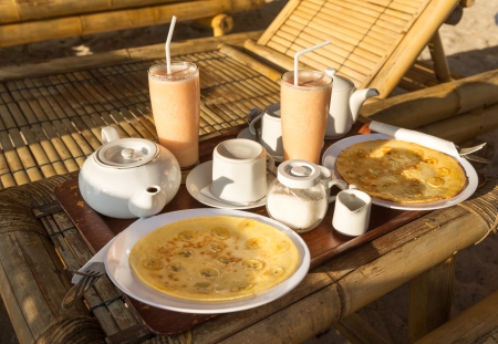 Plates with dishes served at the beach beside tanning bedsの写真素材