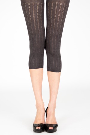 Long Slim legs wearing colorful leggins on plain backgroundの写真素材