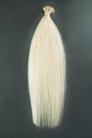 Blond hair extensions shot on a dark backgroundの写真素材