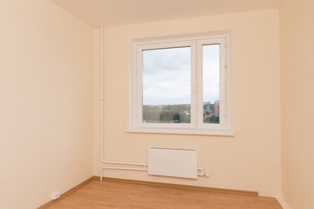 Generic empty room with window and heat radiatorの写真素材