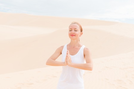 Young woman practicing yoga in the desertの写真素材