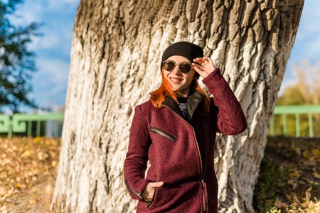 Fashion slim young woman walking in autumn parkの写真素材