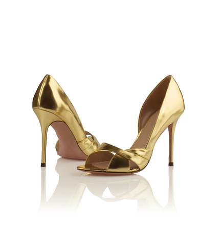 Pair of golden modern fashionable women shoes shot in studioの写真素材