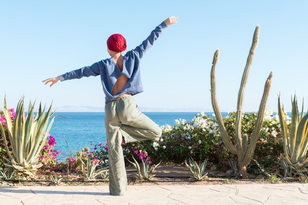 Woman doing yoga asana at sea resortの写真素材
