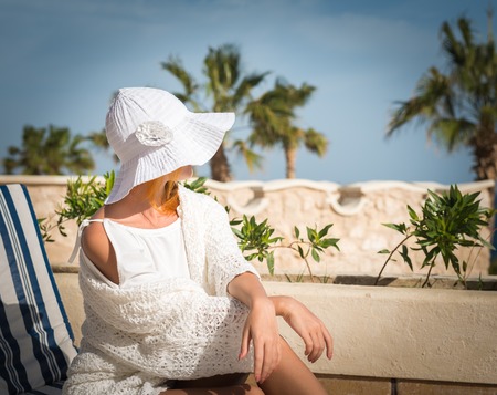 Young woman enjoying sun on sunbed at tourist resortの写真素材