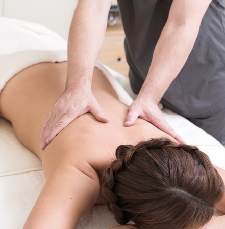Masseur doing massage on woman back in the spa salonの写真素材
