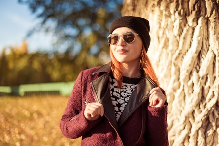 Fashion slim young woman walking in autumn parkの写真素材