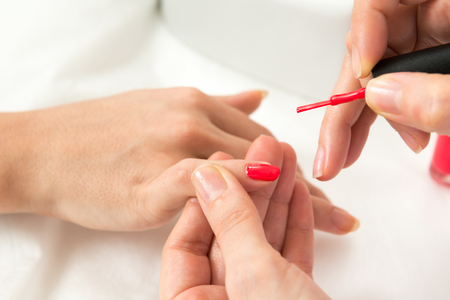 Manicure process in beauty salon close up of female handsの写真素材