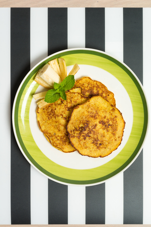 Delicious banana pancakes on a plate with green mintの写真素材