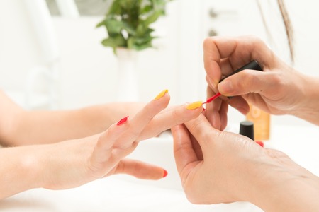 Manicure process in beauty salon close up of female handsの写真素材