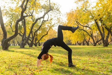 Woman doing yoga in autumn parkの写真素材