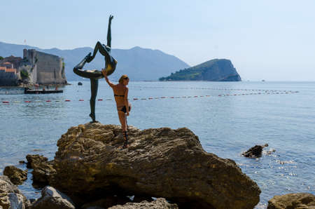 Tourist posing for a photo near statueの写真素材