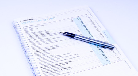 cash flow statement with pen on white backgroundの写真素材