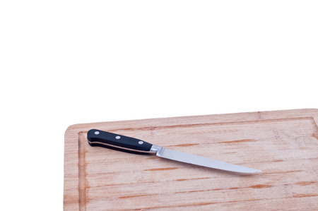 aged wooden chopping board and black and silver knife on a white 