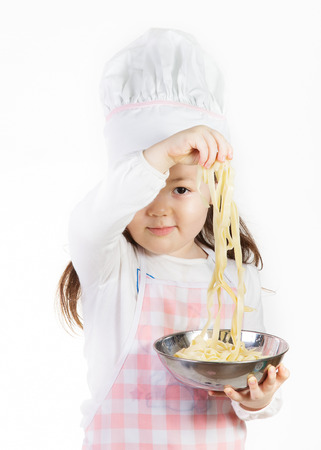 A young chef enjoys using noodles to make something good to eat.の写真素材