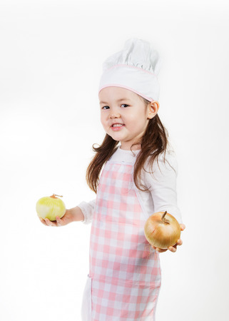 A young girl uses fresh onions to make something good to eat.の写真素材