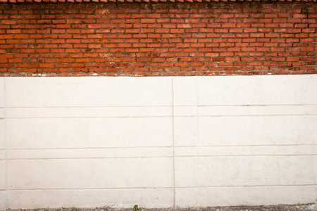 A blank slightly weathered conrete and brick wall perfect for background and messages.の写真素材