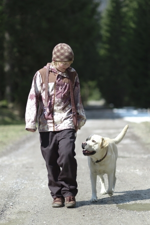 Young boy handling his dog on walking through the forestの写真素材