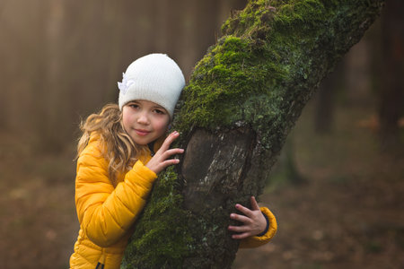 portrait of young girly in the forest, rest head on the treeの写真素材