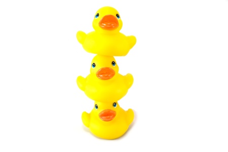 Three little rubber ducks stacked isolated on whiteの写真素材