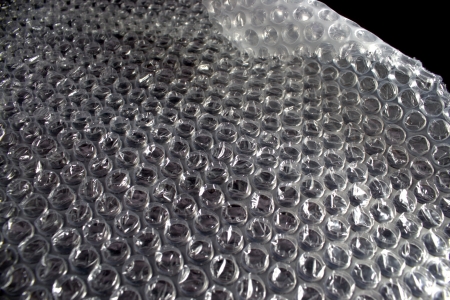Piece of air bubble packing on black background with the corner curled up