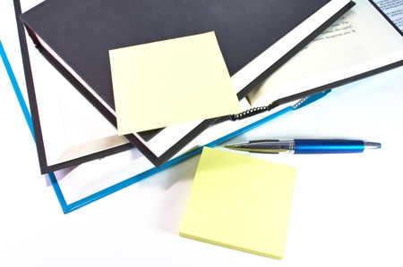 Books and sticky notes with pen isolated on white