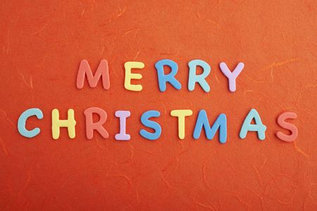 Merry christmas text (colorful soft rubber letters) on red silk paperの写真素材