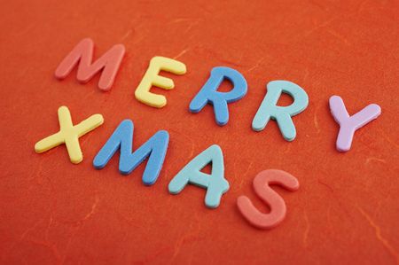 Merry christmas text (colorful soft rubber letters) on red silk paperの写真素材