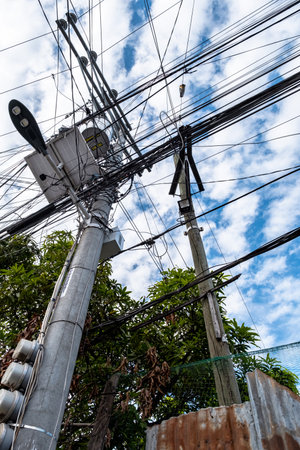 Low angle view of Tangled telephone cablesの写真素材