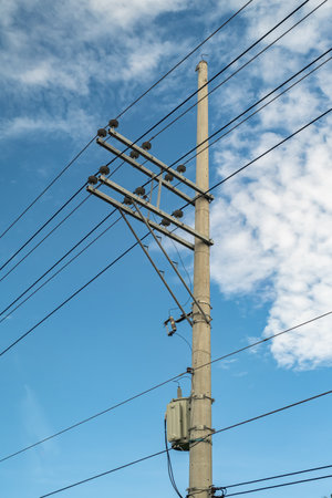 Electric pole and electric transformer with a clear blue sky background in portrait formatの写真素材