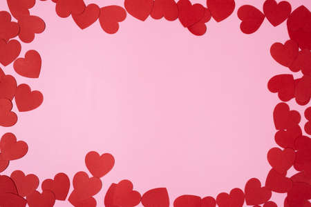 Heart frame with heart shaped paper confetti with blank pink background. Perfect for Valentines day creative compositions in prints and social media.の写真素材