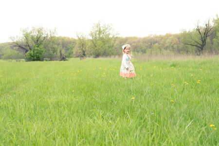 Little girl standing in the field far away の写真素材