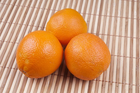 Three orange on bamboo backgroundの写真素材