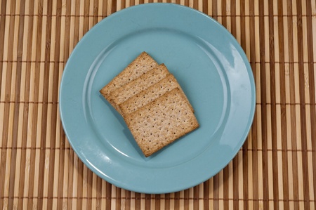 Blue plate inside the cracker on bamboo backgroundの写真素材