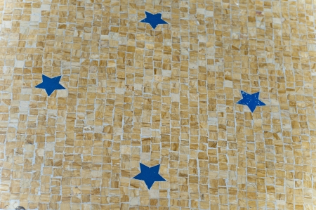 Blue stars on the yellow ground mosaic on milano italyの写真素材