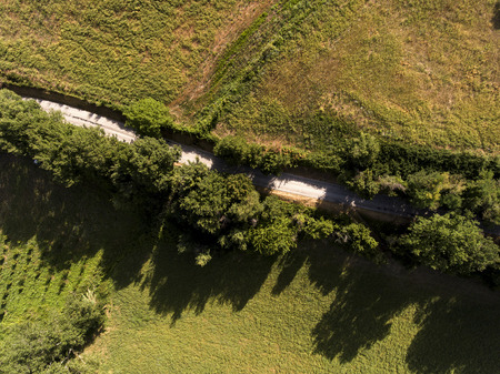 country road crossing nature at sunset aerial viewの写真素材