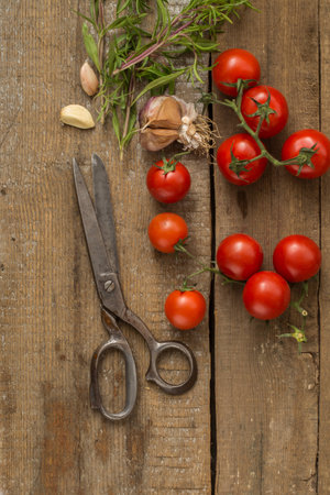 Cherry Tomatoes, Garlic & Scissors On The Wooden Backgroundの写真素材
