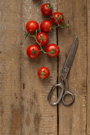 Cherry Tomatoes & Scissors On The Wooden Backgroundの写真素材