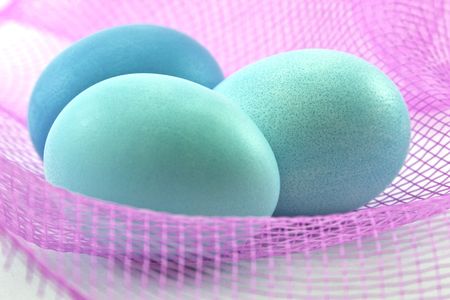 blue easter eggs on pink netの写真素材